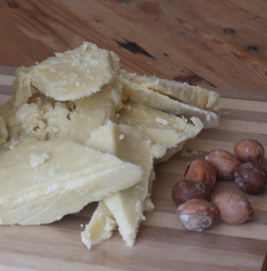 raw shea butter and shea nuts on a table