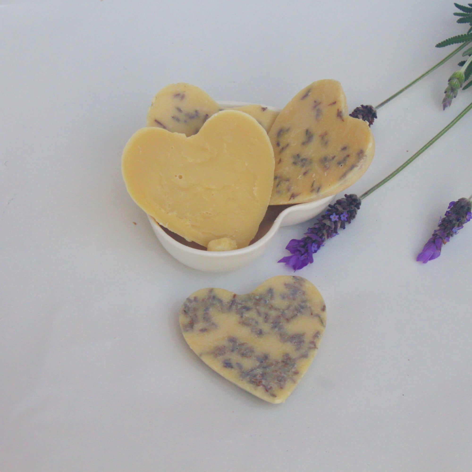 Lotion bar made with shea butter, cocoa butter and beeswax.  lotion bar with lavender essential oil and lavender flowers