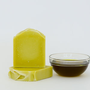 Two Avocado and Aloe Handmade Soap bars  and a small glass bowl with unrefined avocado oil in a glass bowl
