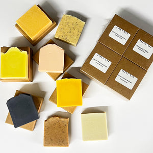 Small batch handmade cold process soaps displayed in artisan kraft packaging.